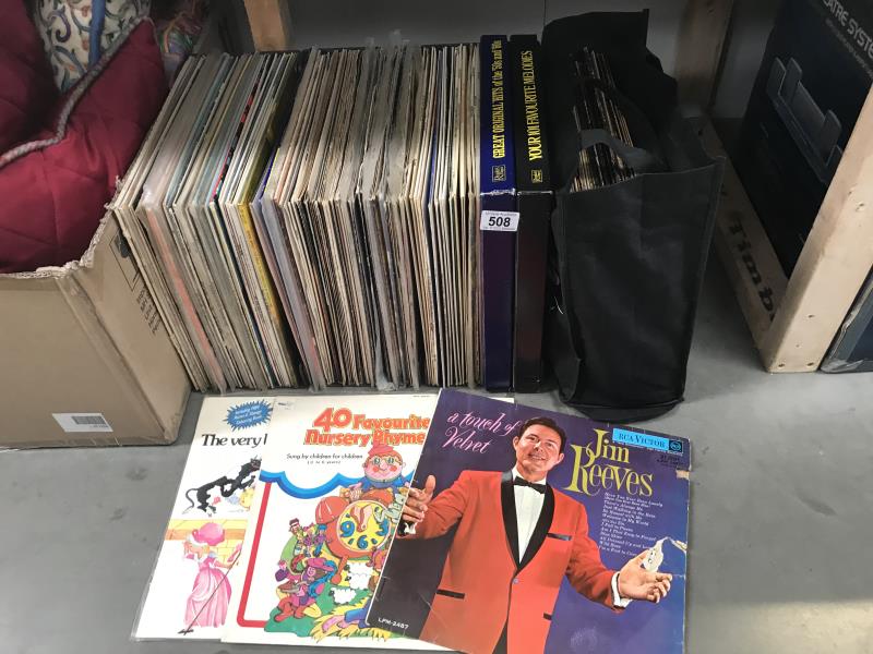 A collection of LP records in 3 storage brackets and a shopping bag