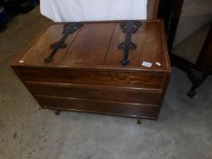 A mahogany blanket box with large iron hinges.