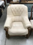 A cream leather lounge chair on oak frame