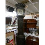 A heavily carved long case clock with 8 day movement and brass dial.
