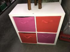 A child's cupboard with drawers and contents.