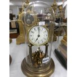 A Brass clock with enamel dial under glass dome.