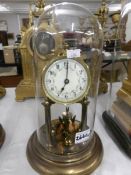 A Brass clock with enamel dial under glass dome.