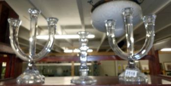 A pair of glass candelabra and a glass candlestick.