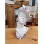 A ceramic bust of a lady in hat.