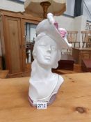 A ceramic bust of a lady in hat.