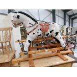 A fabric rocking horse on wooden base.