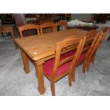 A pine dining table with 6 chairs.