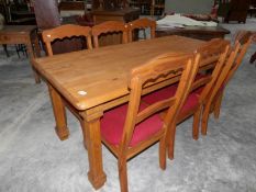 A pine dining table with 6 chairs.