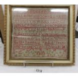 A framed and glazed 19th century sampler by Ruth Tomlinson, aged 9 years, 1850.