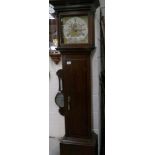 An oak 30 hour grandfather clock with brass dial and chapter ring.