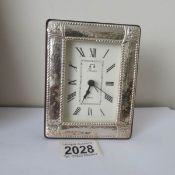 A modern clock with silver front.