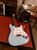 A blue Strat style guitar with a Gorilla 20w amp and lead.