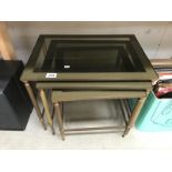 A brass framed nest of 3 tables.