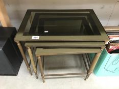 A brass framed nest of 3 tables.