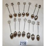 14 white metal teaspoons with coat of arms finials.