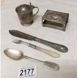 A silver mustard pot, a silver match box holder, a silver spoon,