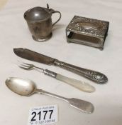 A silver mustard pot, a silver match box holder, a silver spoon,