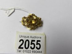 A yellow metal brooch,