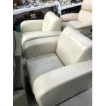 A pair of cream arm chairs.