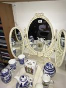 A three fold bedroom mirror with decorative frame.