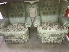 A pair of green upholstered armchairs.