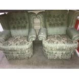 A pair of green upholstered armchairs.
