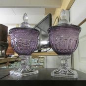 A good quality pair of amethyst cut glass lidded urns.