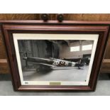 A framed and glazed print of a Spitfire signed by pilots Mark and Ray Hanna.