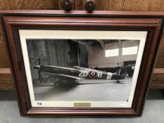 A framed and glazed print of a Spitfire signed by pilots Mark and Ray Hanna.