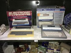 A boxed V tech Precomputor 2000 and a boxed petite electronic typewriter.