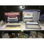 A boxed V tech Precomputor 2000 and a boxed petite electronic typewriter.