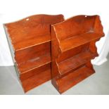 A pair of yew wood hanging bookshelves.