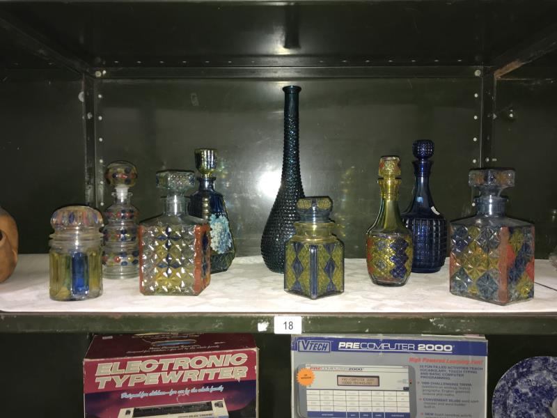 A quantity of coloured glass decanters.