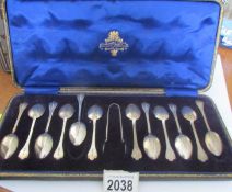 A cased set of 12 silver teaspoons with sugar tongs.