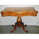 A Victorian walnut fold over card table.