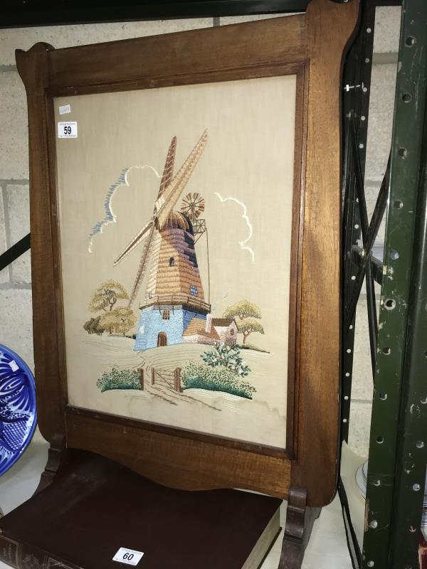 A tapestry of a windmill in a mahogany frame.