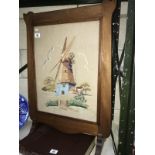 A tapestry of a windmill in a mahogany frame.