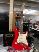 A Red Squire Strat guitar with 10w Park amp and lead.