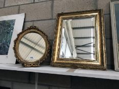 A decorative gilded mirror and one other.