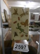An ivory card case decorated with reptiles and insects.