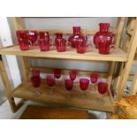 2 shelves of cranberry glass including jugs, bowls and wine glasses.