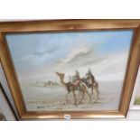A framed oil on canvas depicting camels in a desert signed Jing H Jee.