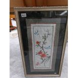 A framed and glazed embroidery depicting flowers and birds.