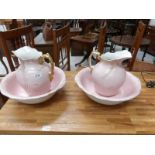 A pair of pink jug and basin sets, a/f.