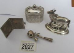 A white metal engraved box, a cow with calf, a photo frame and a rattle (possibly silver).