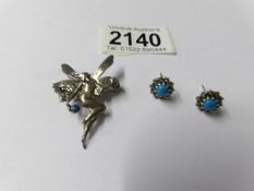 A silver fairy brooch and a pair of silver earrings.