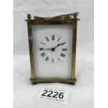 A brass carriage clock with key.