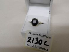 An 18ct gold ring set jet stone and 2 diamonds, size O, gross weight 4 grams.