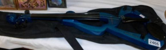 An electric violin and bow in case.